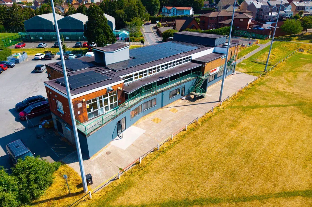 The rear of the building with solar panels overlooking the playing field