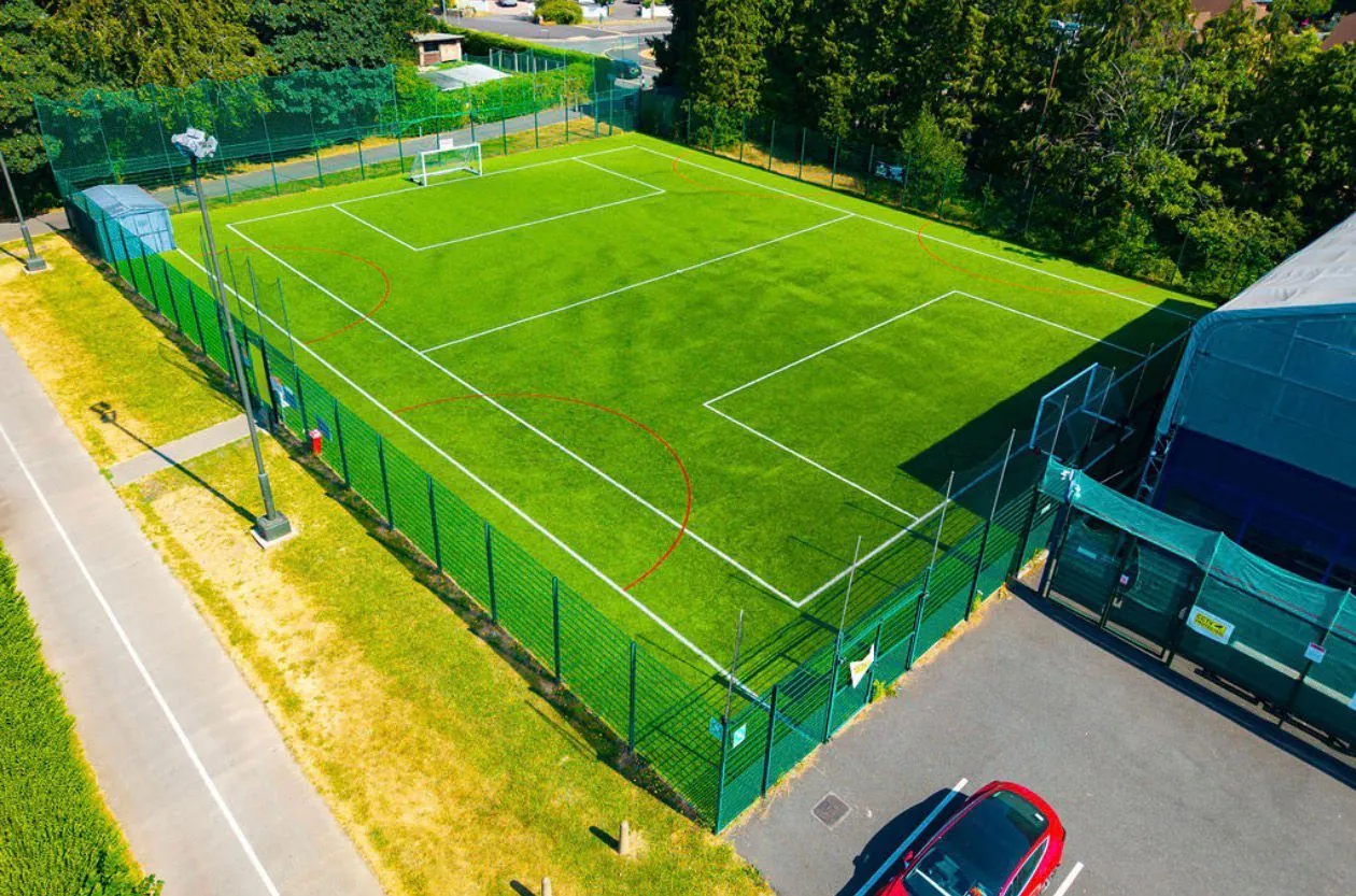 Aerial view of the floodlit Cwmbran 3G pitch surrounded by trees